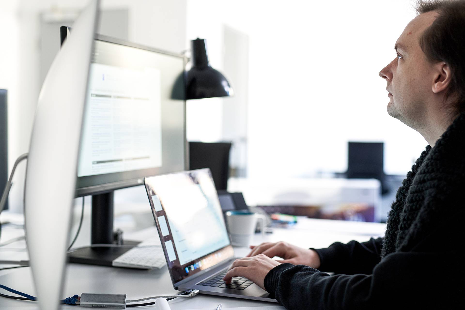 Online Marketing Experte bearbeitet konzentriert ein Reporting am PC